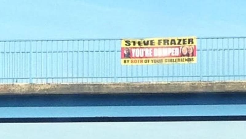 Plakát visel na mostě přes silnici, kudy pojíždí denně tisíce aut, včetně Steva Frazera.