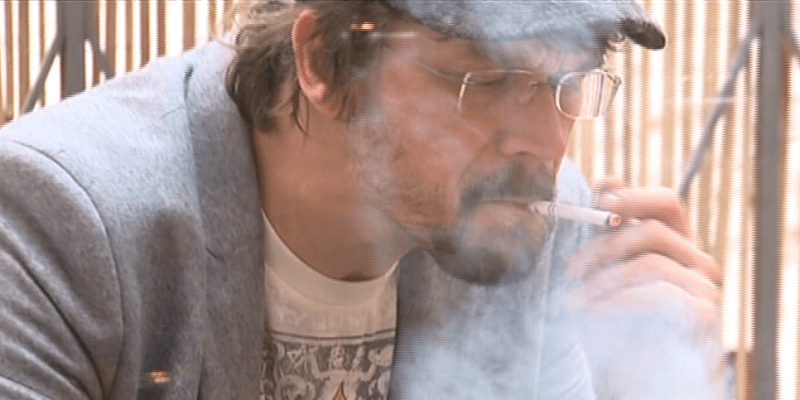 Zpěvák Dan Bárta zahalený v oblacích cigaretového dýmu