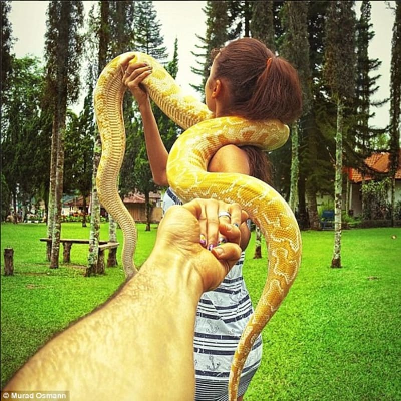 Nataly s velkým žlutým hadem, stočeným kolem jejího krku v Bali, Indonésie