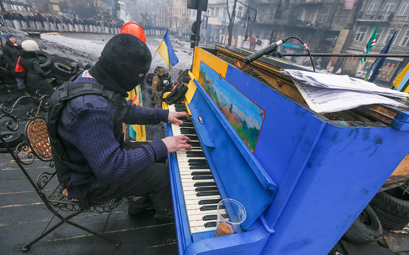 Klavír z projektu "Play me, I‘m yours"... Ukrajinský demonstrant hraje na klavír na barikádě (Kyjev, Ukrajina, 2014)