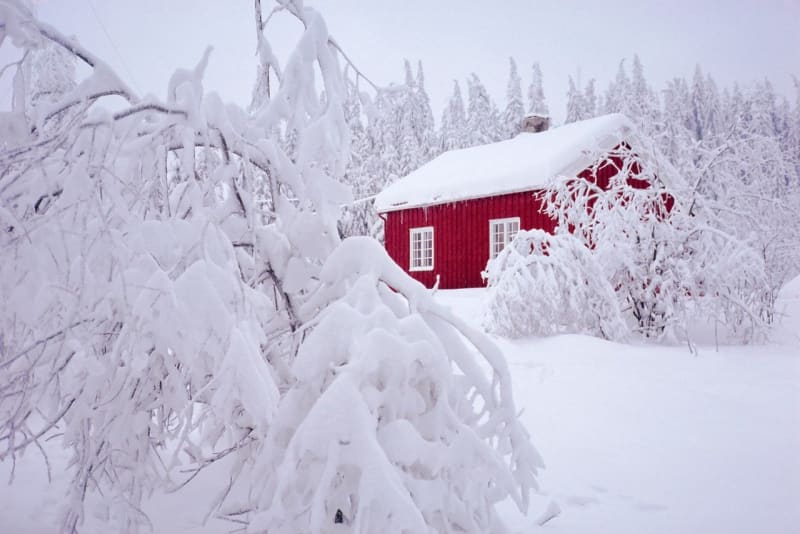 Úžasný kontrast červené chaloupky a bílého sněhu, Nordmarka, Oslo, Norsko, Skandinávie