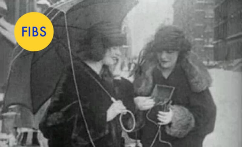 Mobilní telefon v roce 1922? Ne! Jedná se o přenosné rádio, které dámy na ulici poslouchají.
