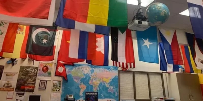 Učitel vyvěsil do třídy vlajky všech zemí, z nichž pochází jeho studenti.