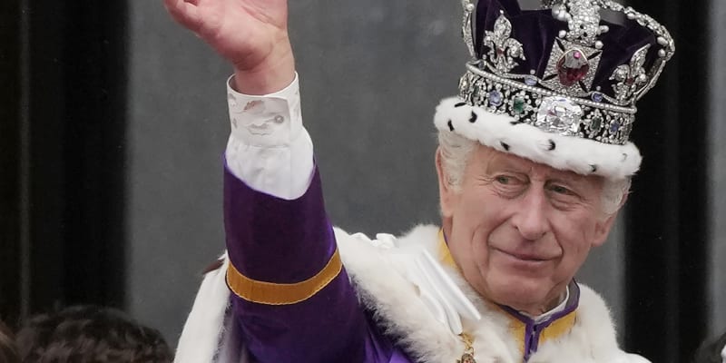 Král Karel III. zdraví davy z paláce.