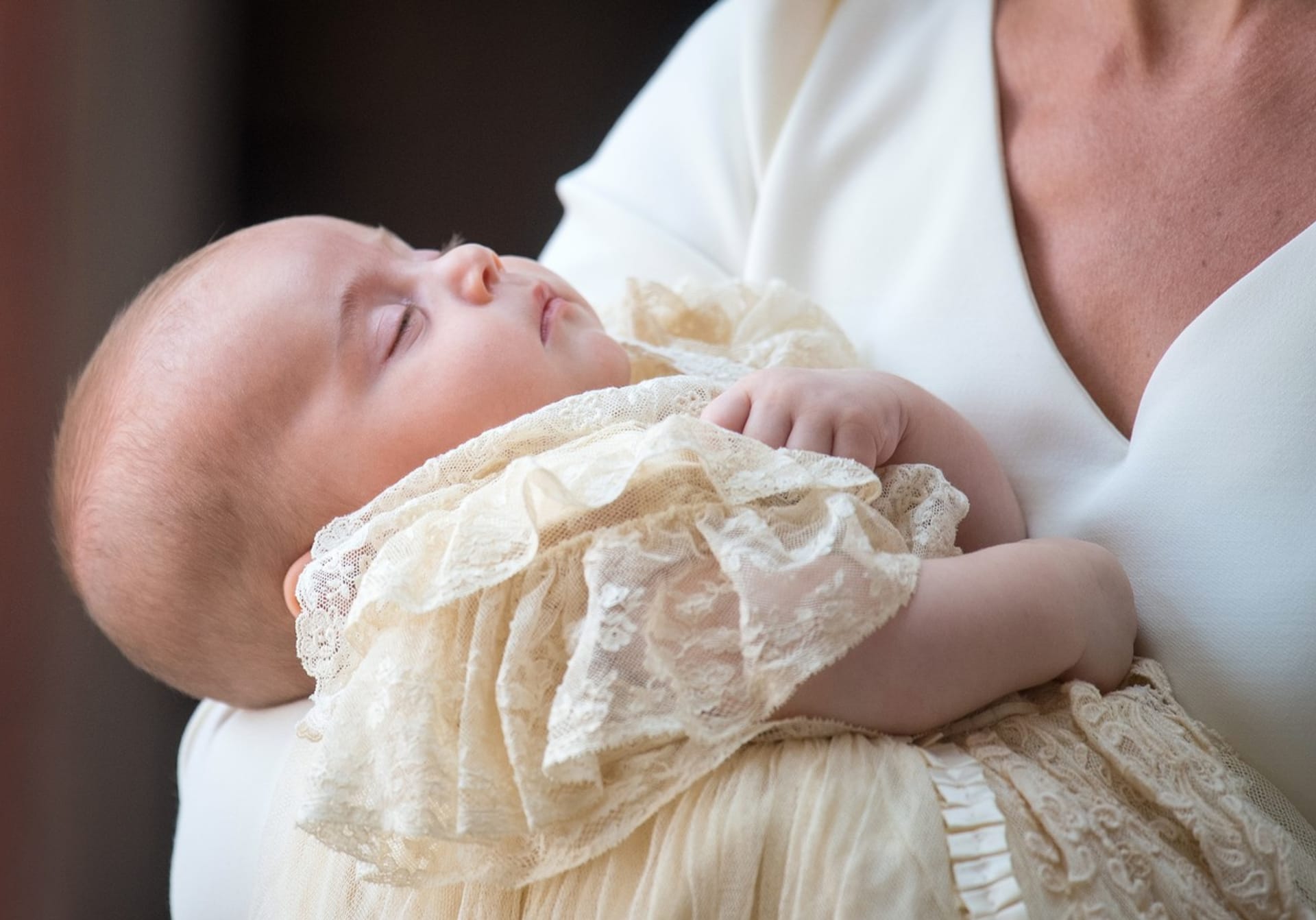 Princ Louis při křtinách v náručí maminky Kate.