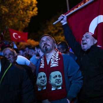 Příznivci tureckého prezidenta Recepa Tayyipa Erdogana sledují zprávy na obří obrazovce před sídlem Strany spravedlnosti a rozvoje (AKP) v tureckém Istanbulu v neděli 14. května 2023. Hlasovat mohlo více než 64 milionů lidí, včetně 3,4 milionu voličů ze zahraničí. (AP Photo/Francisco Seco)
