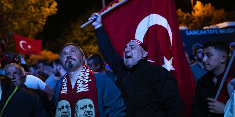 Příznivci tureckého prezidenta Recepa Tayyipa Erdogana sledují zprávy na obří obrazovce před sídlem Strany spravedlnosti a rozvoje (AKP) v Istanbulu v neděli 14. května 2023. Hlasovat mohlo více než 64 milionů lidí, včetně 3,4 milionu voličů ze zahraničí. (AP Photo/Francisco Seco)