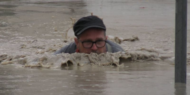 Muž v centru města Cesena překonává zaplavenou ulici 