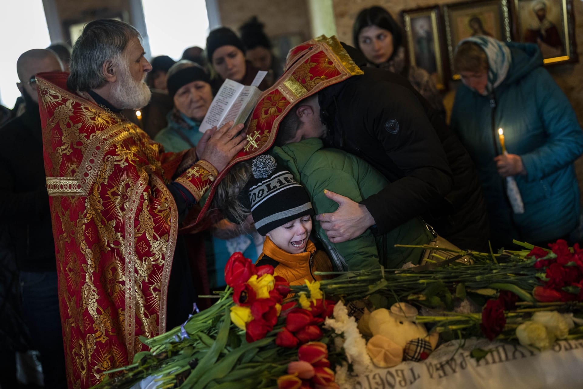 Malý Michajl pláče u rakve své 11leté sestry, která zemřela po ruském útoku na město Umaň