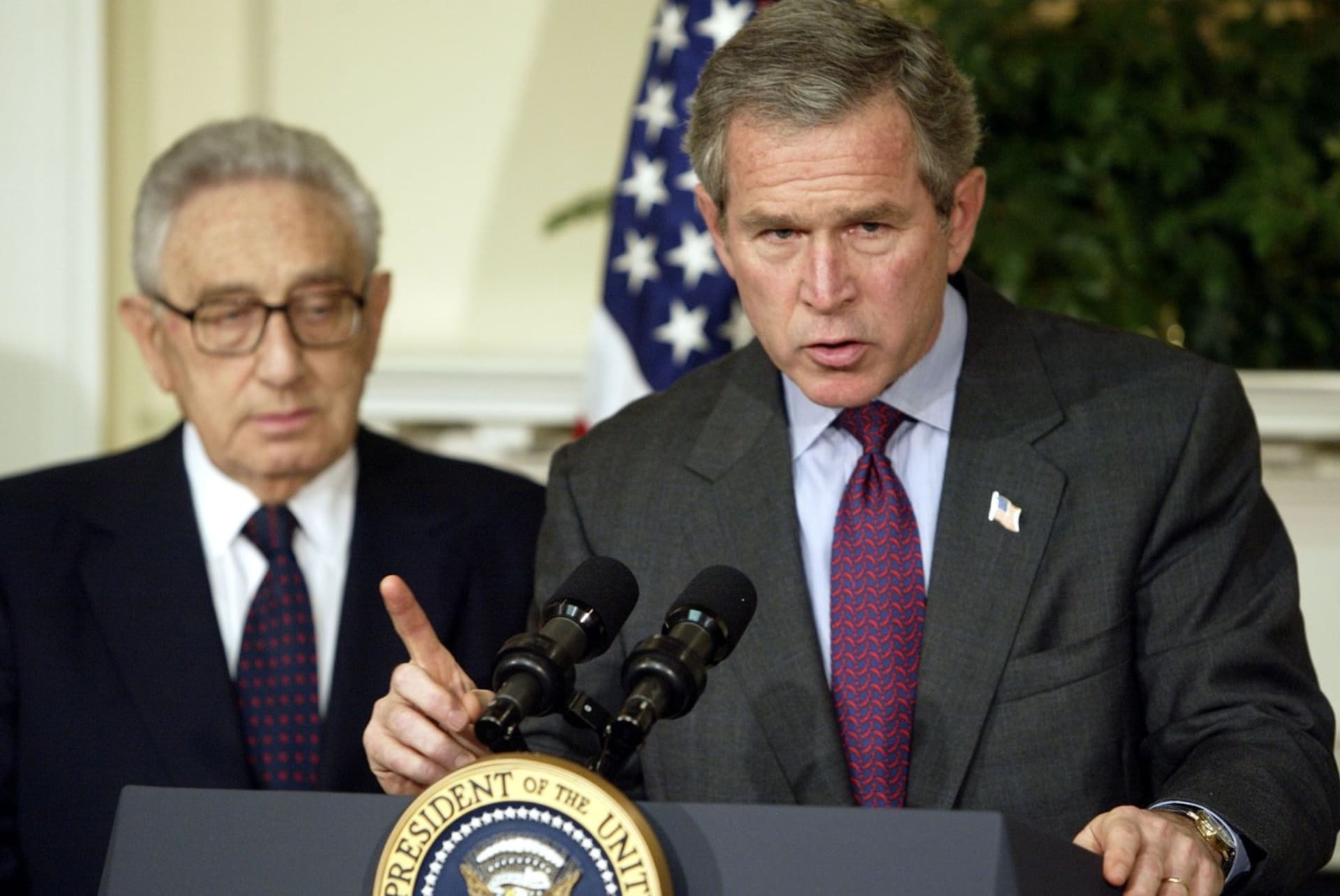 George Bush mladší vyhlašuje po útocích z 11. září protiteroristické zákony, Kissinger stojí v pozadí
