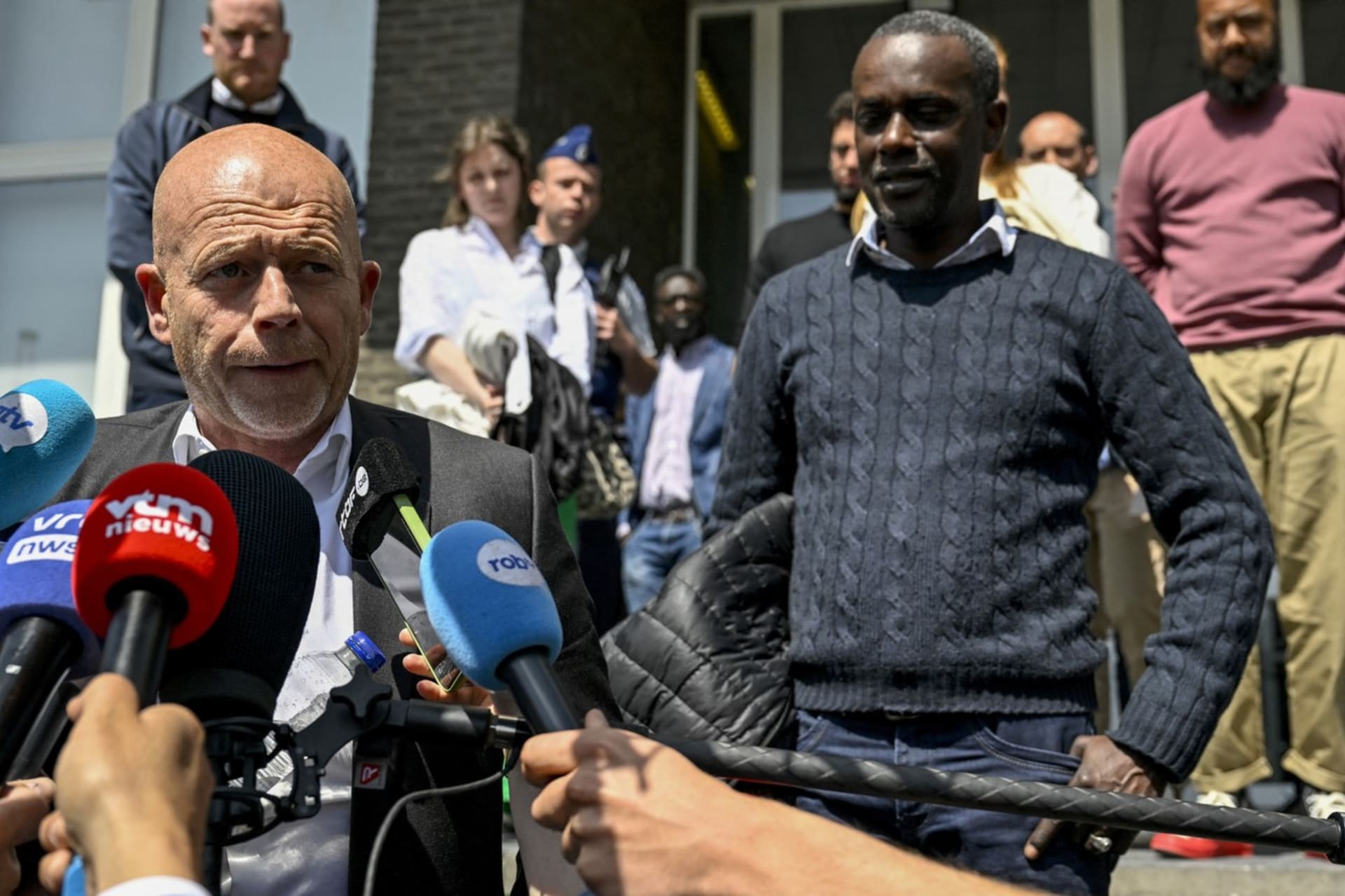 Právní rodiny (vlevo) a otec zemřelého studenta (vpravo) odpovídají novinářům před budovou soudu v Antwerpách