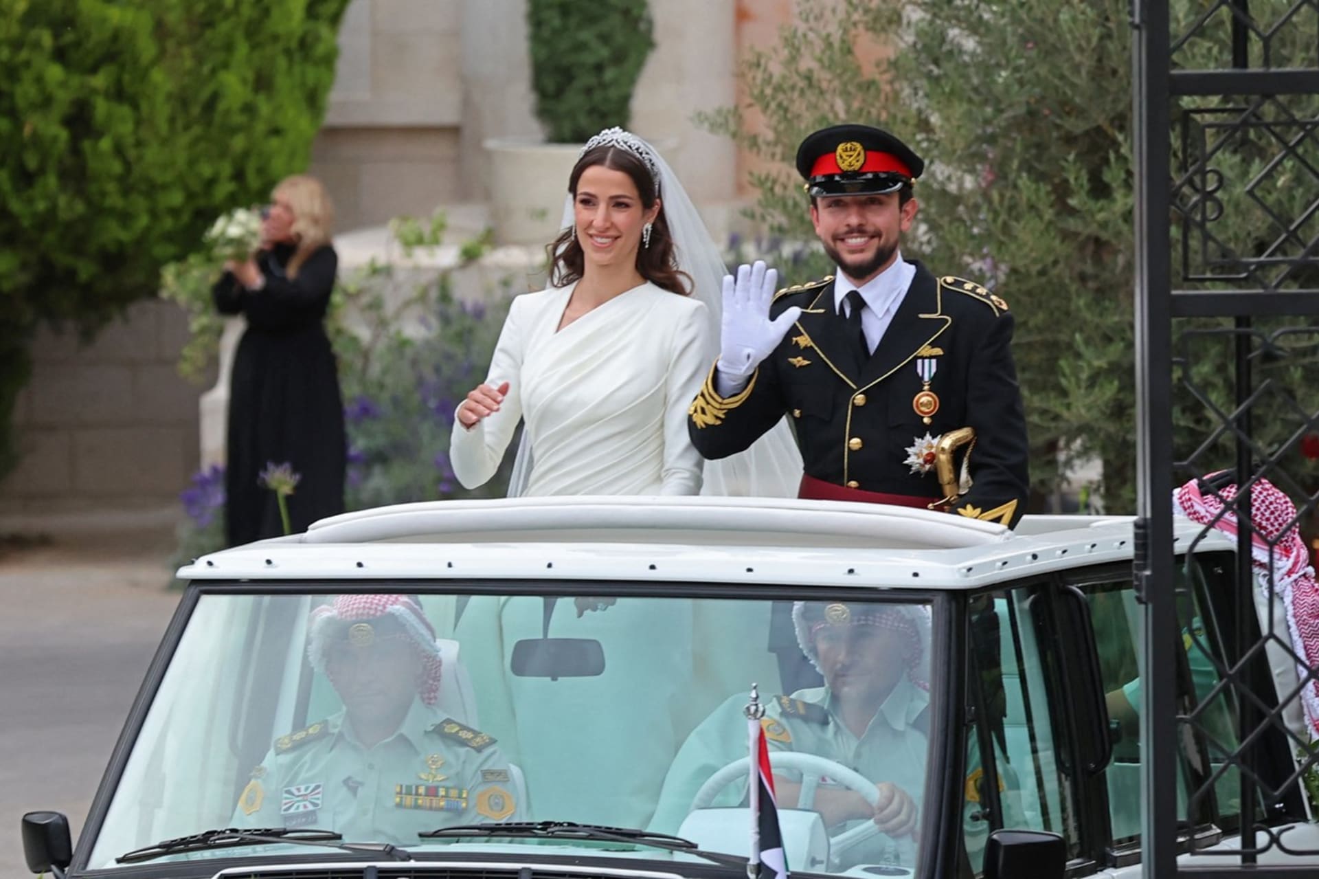 Novomanželé korunní princ Husajn a Rádžva ve voze, kterým projíždějí ulice jordánské metropole.