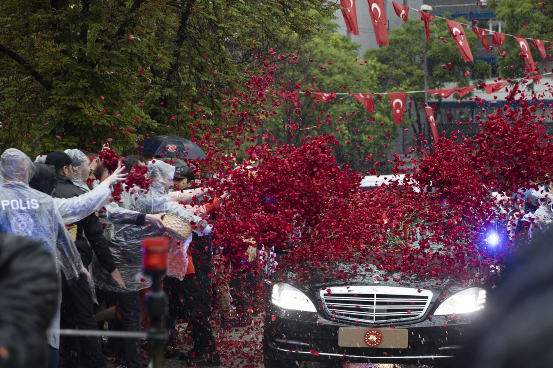 Lidé před parlamentem Erdogana vítali okvětními lístky růži, které mu házeli na auto.