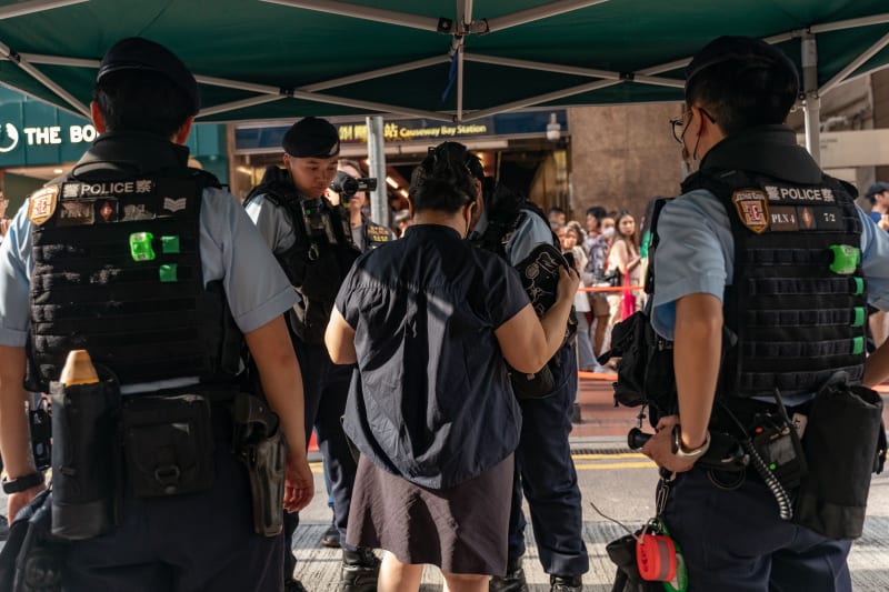 Policisté v Hongkongu prohledávají demonstranty (4. 6. 2023).