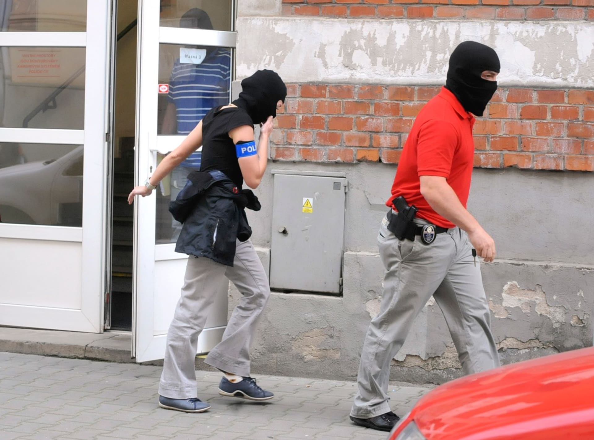 Policisté, kteří přivezli 14. června 2013 zadrženou nejbližší spolupracovnici premiéra Petra Nečase Janu Nagyovou na policejní služebnu v ostravské Masné ulici, vycházejí z budovy.