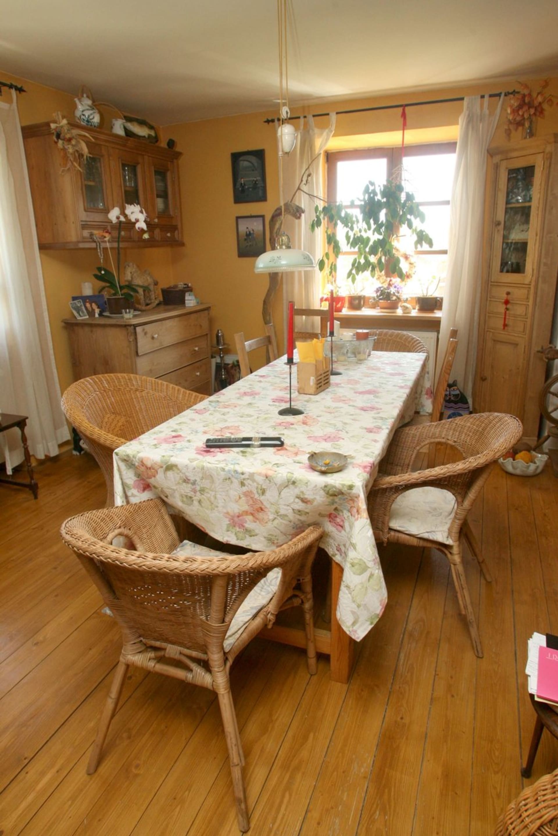 V jídelně je ratanové sezení a bytelný dřevěný stůl