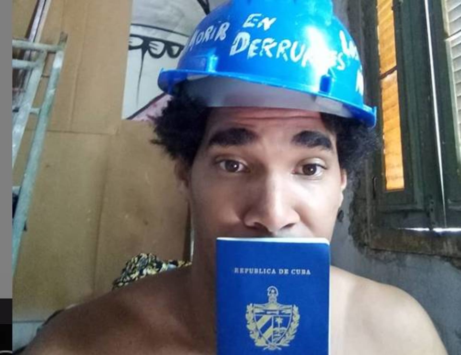 Umělec Otero Alcantara s helmou po Havaně a kubánským pasem