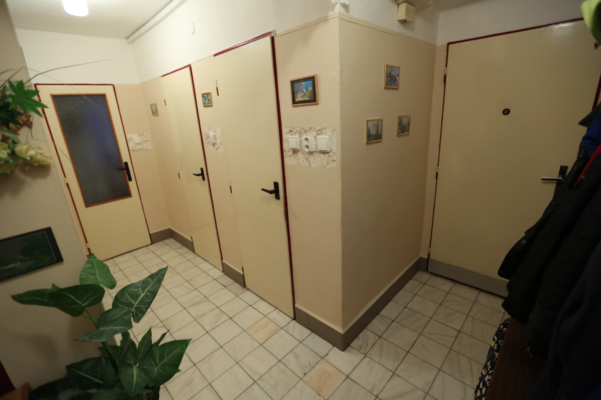 Napravo vstupní dveře, potom toaleta s koupelnou a úzké prosklené dveře vedoucí do kuchyně