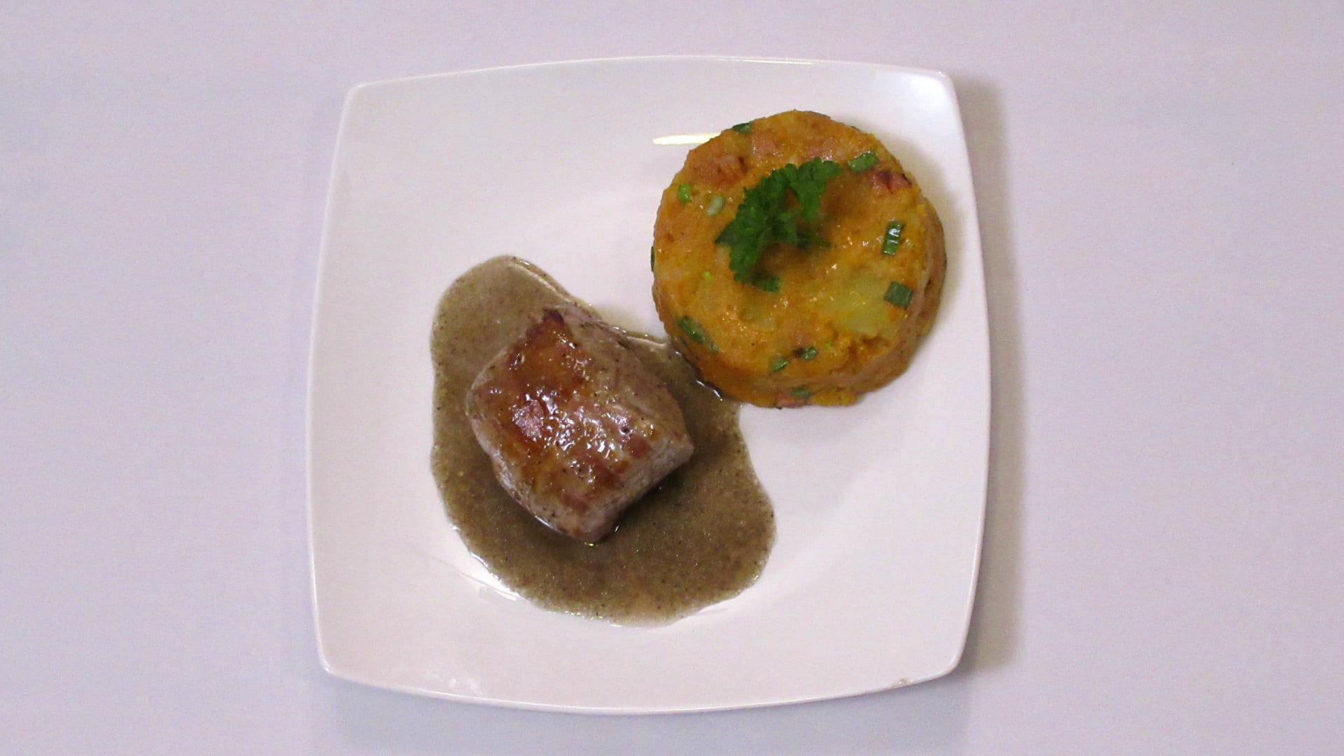 Steak z vepřové panenky na pepři čtyř barev se sosem a kovářské šťouchané brambory