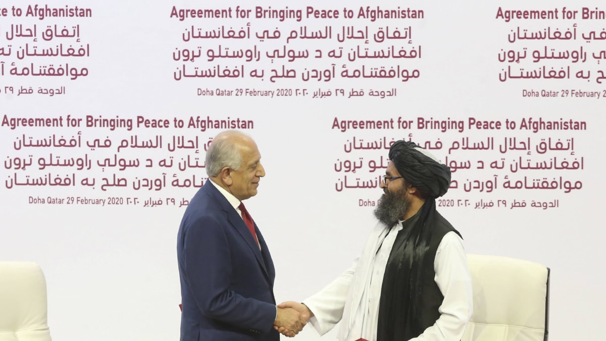 Mullah Abdul Ghani Baradar za Tálibán a Zalmay Khalilzad za USA podepisují mírovou dohodu