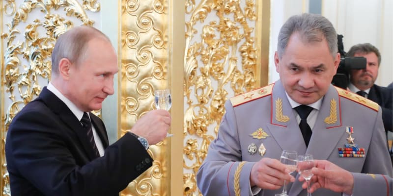 Vladimir Putin (vlevo) a ministr obrany Sergej Šojgu s panákem vodky