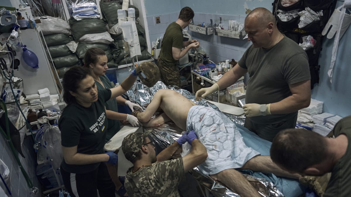 Zdravotníci poskytují první pomoc zraněnému ukrajinskému vojákovi poblíž Bachmutu