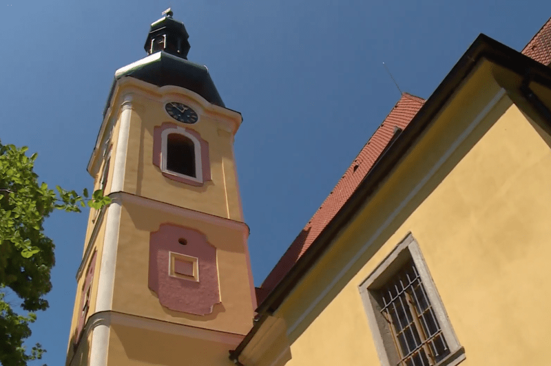 Věž kostela, na které je umístěna kamera, která čápce s mláďaty sleduje.