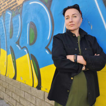 Ukrajinská spisovatelka Kateryna Kalytko před graffiti Sláva Ukrajině ve Lvově.