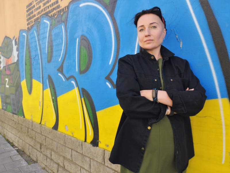 Ukrajinská spisovatelka Kateryna Kalytko před graffiti Sláva Ukrajině ve Lvově.