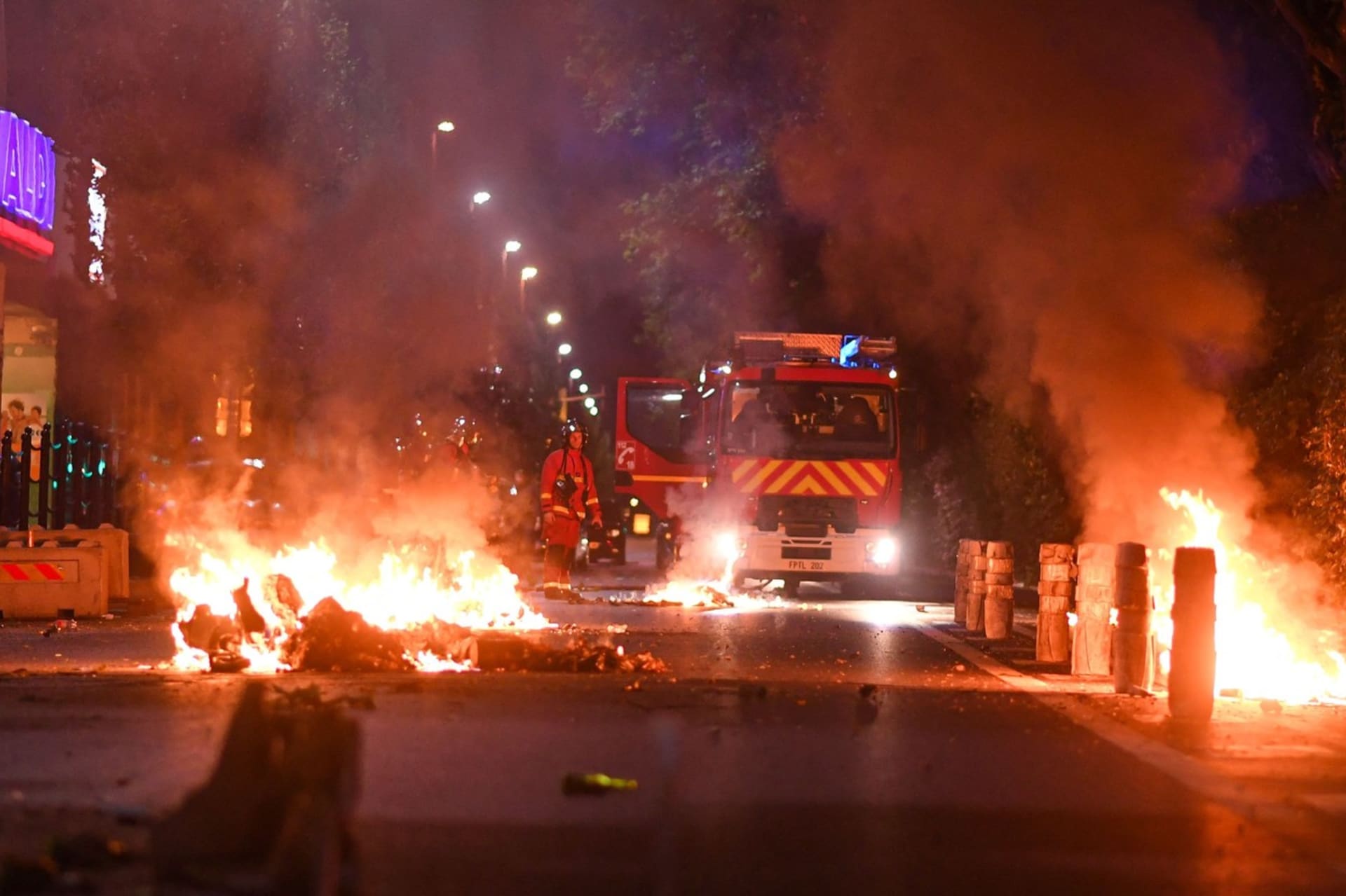 Protestující zapalují auta a popelnice.