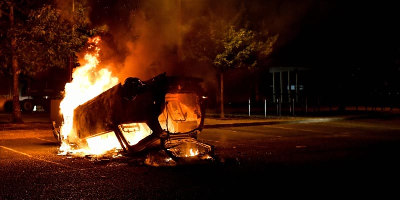 Hořící auto ve městě Talence poblíž Bourdeaux (1. 7. 2023).