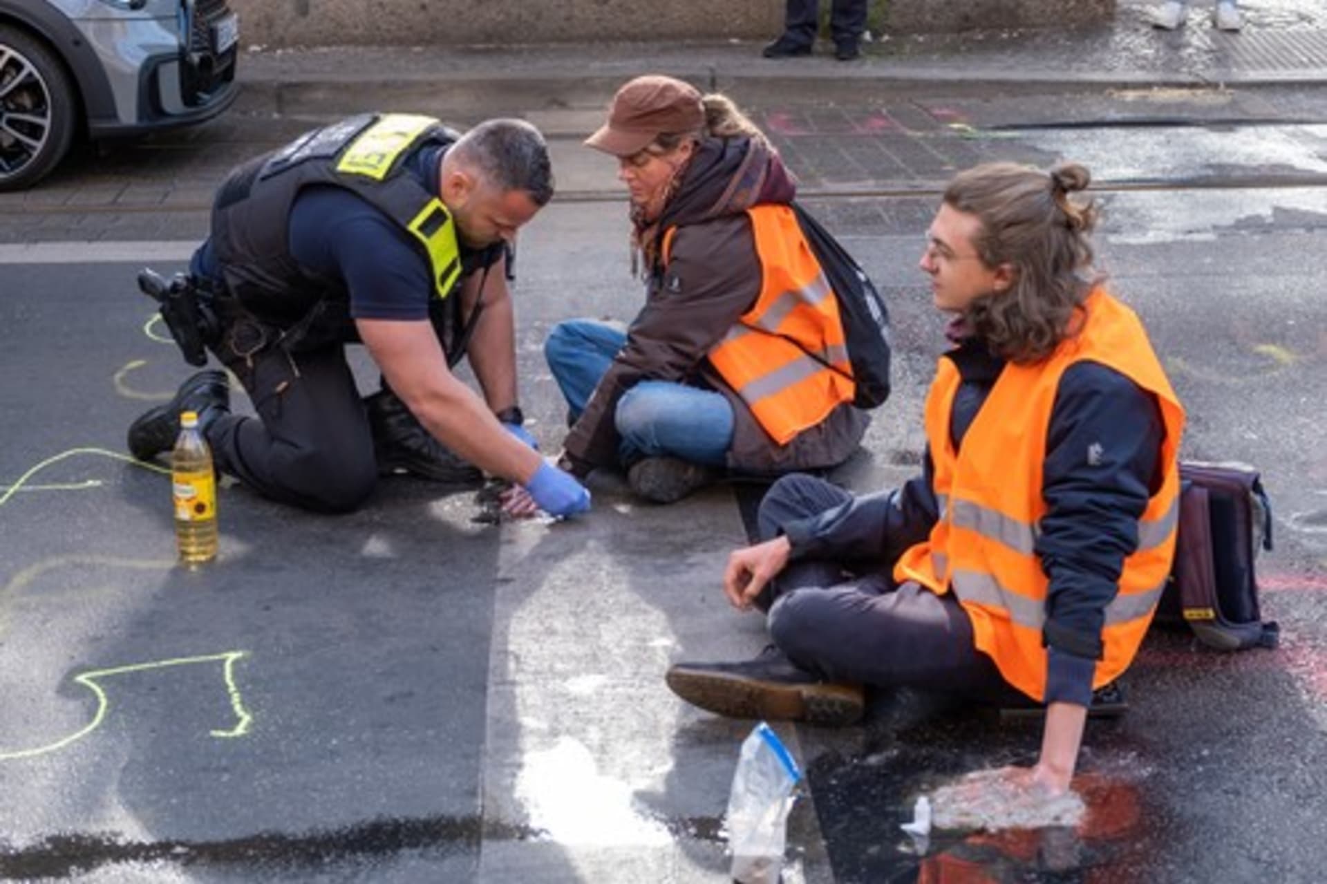 Klimatičtí aktivisté se v rámci protestu přilepují k vozovce (Německo, květen 2023).