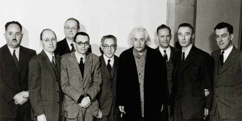Oslava 70. narozenin Alberta Einsteina v Institutu pro pokročilá studia v roce 1949. Z leva doprava stojí H. P. Robertson, E. Wigner, H. Weyl, K. Goedel, I. I. Rabi, Albert Einstein, R. Ladenburg, Julius Robert Oppenheimer a G. M. Clemence.