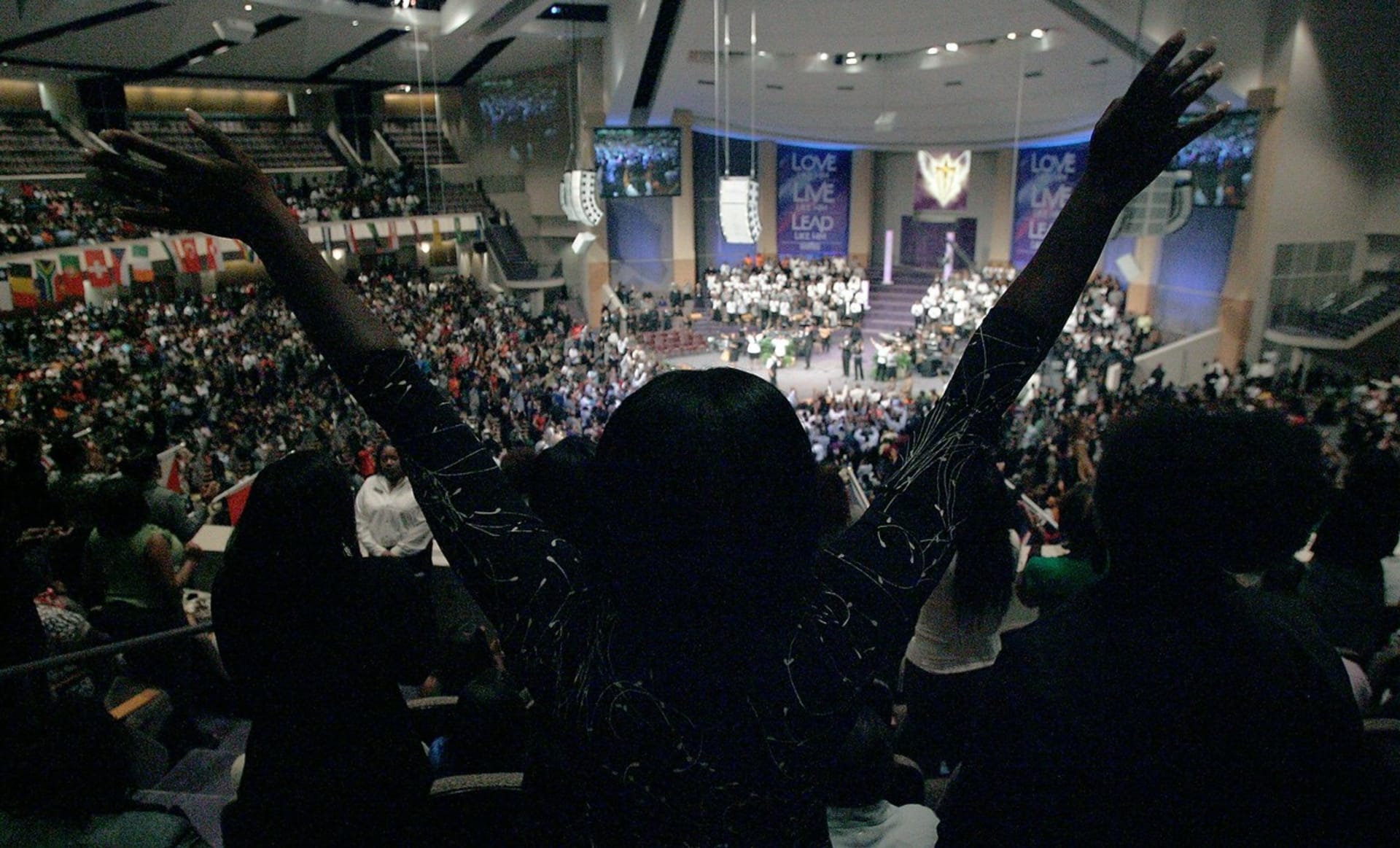 Pastor na podiu i velké obrazovce, kolem něj tisíce věřících. To jsou bohoslužby amerických megacírkví.