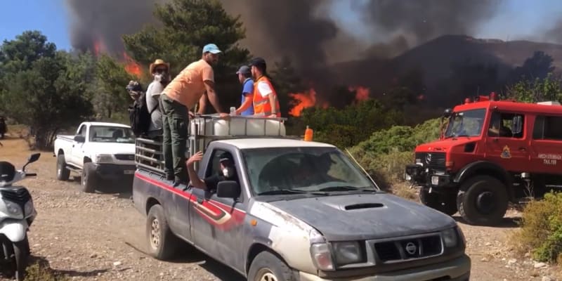 Reportér CNN Prima NEWS se společně s dalšími lidmi přesouvá do bezpečné vzdálenosti od ohně.