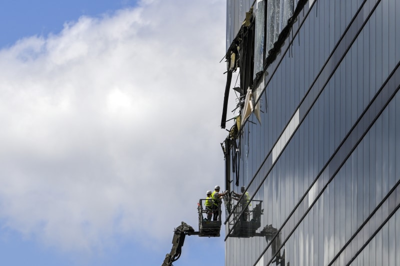 Pracovníci odstraňují trosky z poškozeného moskevského mrakodrapu (30. 7. 2023).
