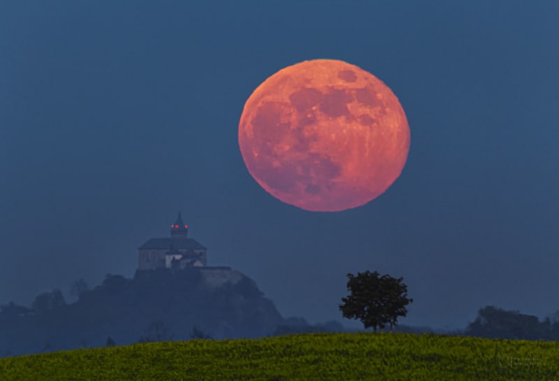 Superúplněk vychází za Kunětickou horou. Vjem velkého Měsíce vůči hradu je důsledkem perspektivy. Načervenalá barva je způsobena zeslabením měsíčního svitu procházejícího zemskou atmosférou