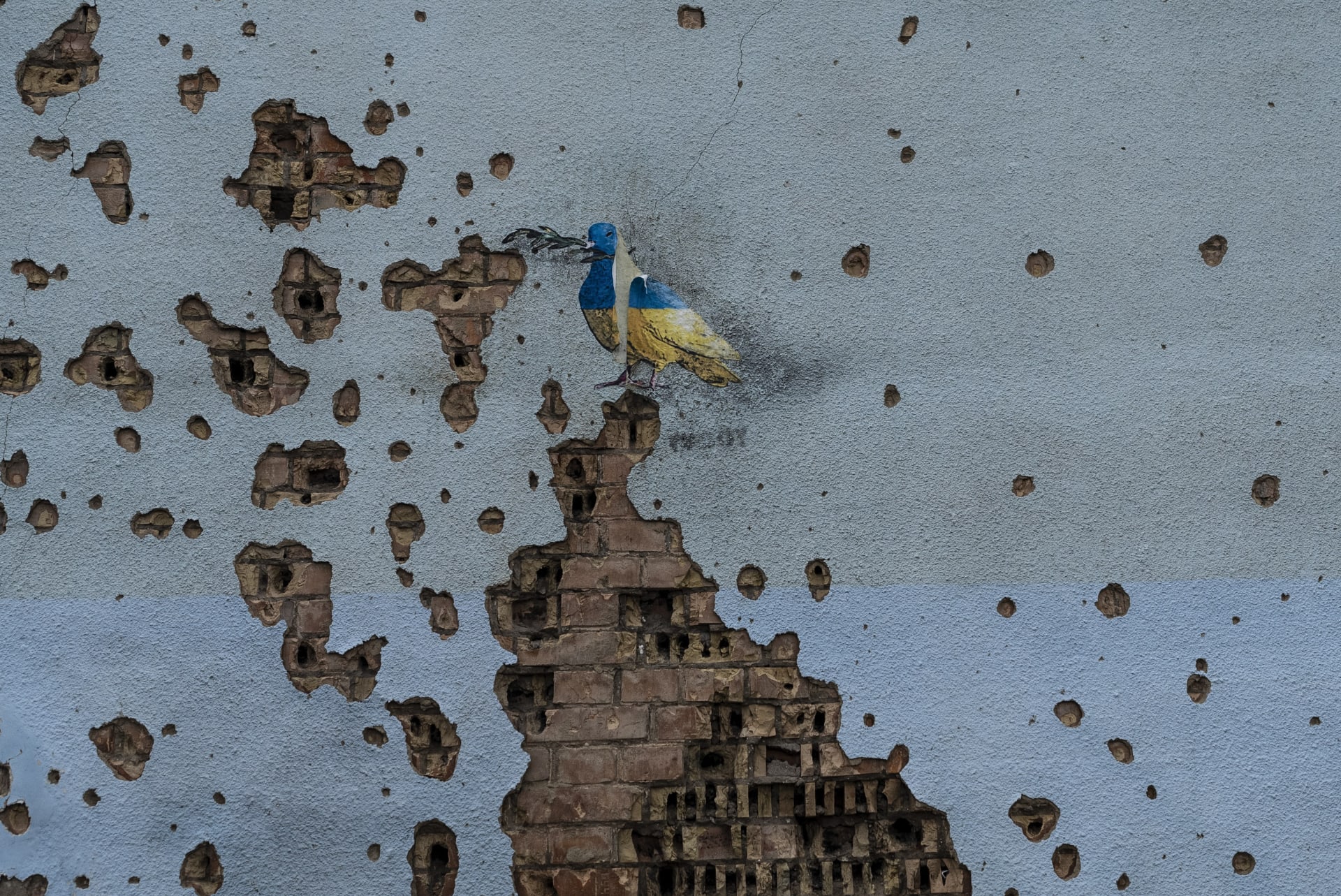 Umělecké dílo na zdi minometným granátem poškozeném domu v Irpini