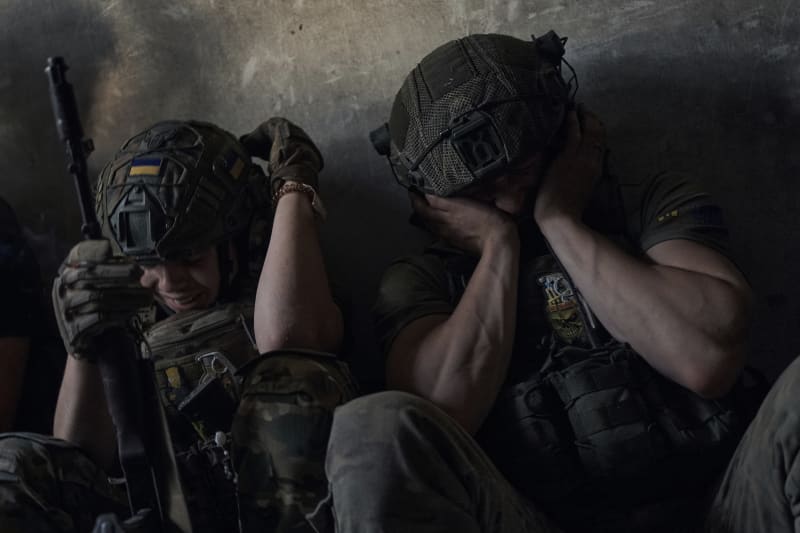 Ukrajinští vojáci na frontové linii v Záporožské oblasti si chrání uši před zvuky ruského ostřelování.