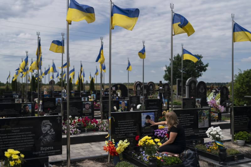 Svetlana klečí u hrobu svého syna Vladyslava na hřbitově v Buči. Ukrajinský voják padl u města Avdijivka na východě země