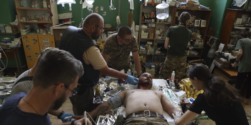 Lékaři pomáhají zraněnému vojákovi v Záporožské oblasti.