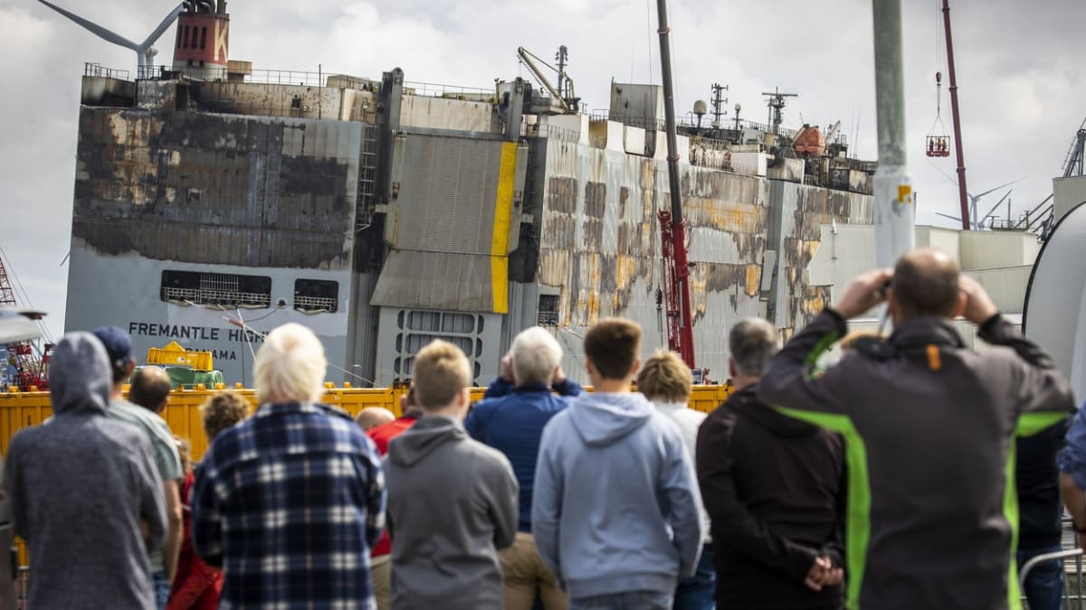 Obyvatelé nizozemského Julianahavenu sledují vykládku neshořelých kontejnerů s auty převážených vyhořelou lodí Fremantle Higway.