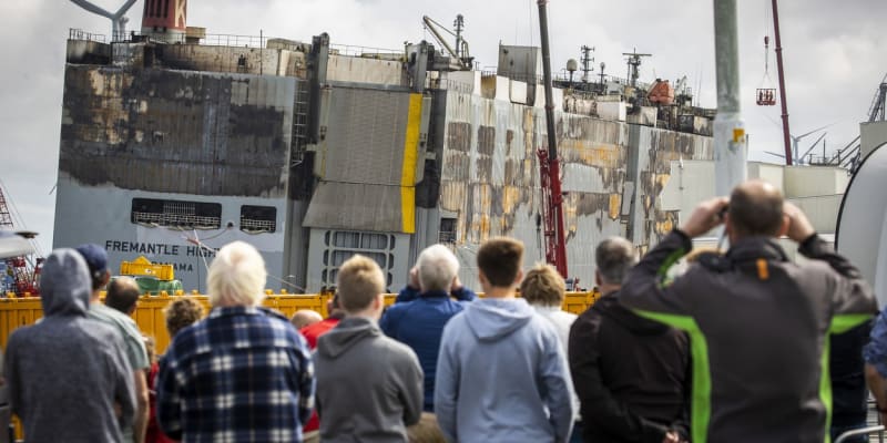 Obyvatelé nizozemského Julianahavenu sledují vykládku neshořelých kontejnerů s auty převážených vyhořelou lodí Fremantle Higway.