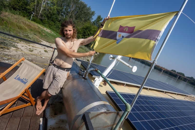 Jeden z místních obyvatel Dorian Štern-Vukoti s liberlandskou vlajkou (24. 8. 2023).