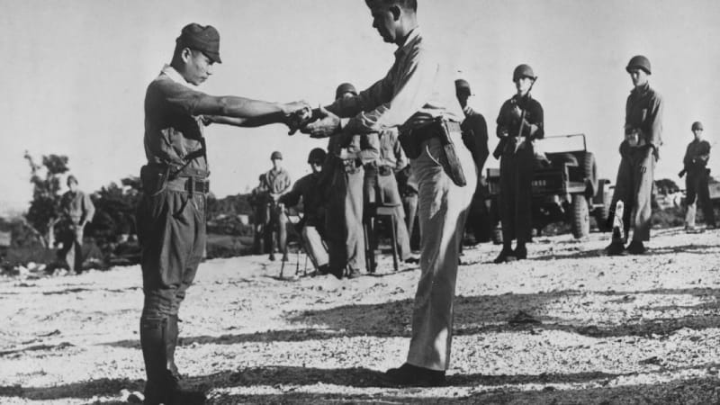Japonský důstojník odevzdává svůj meč americkému podplukovníkovi na Saipanu. Do rukou Američanům se vzdal ž tři měsíce poté, co Japonsko oficiálně podepsalo kapitulaci