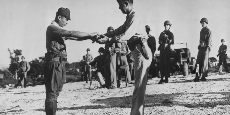 Japonský důstojník odevzdává svůj meč americkému podplukovníkovi na Saipanu. Do rukou Američanům se vzdal ž tři měsíce poté, co Japonsko oficiálně podepsalo kapitulaci