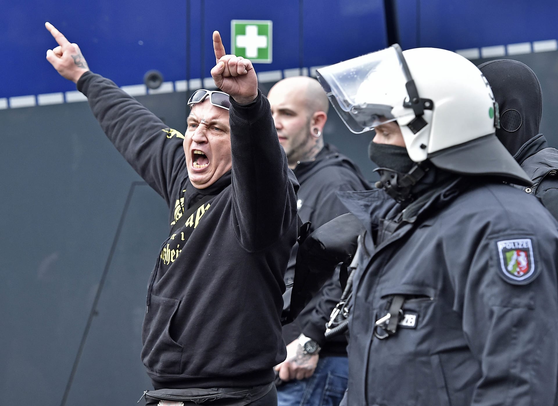 Policie odvádí demonstranta na krajně pravicové akci svolané fotbalovými chuligány.