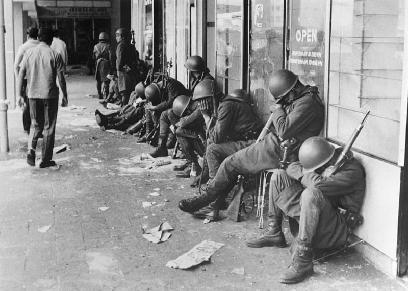 Vojáci po náročné noci odpočívají opření o budovu na Máměstí tří kultur, 3. října 1968