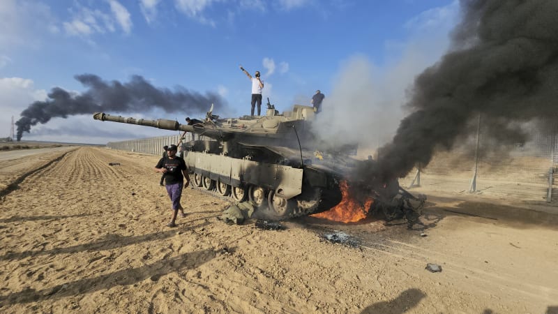 Palestinci oslavují dobytí izraelského tanku v Gaze. (7.10.2023)