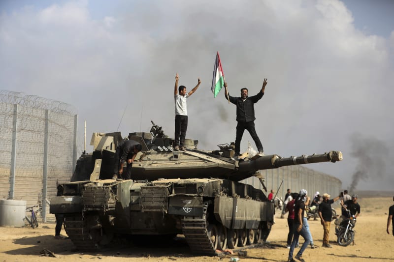 Palestinci oslavují dobytí izraelského tanku v Gaze. (7.10.2023)